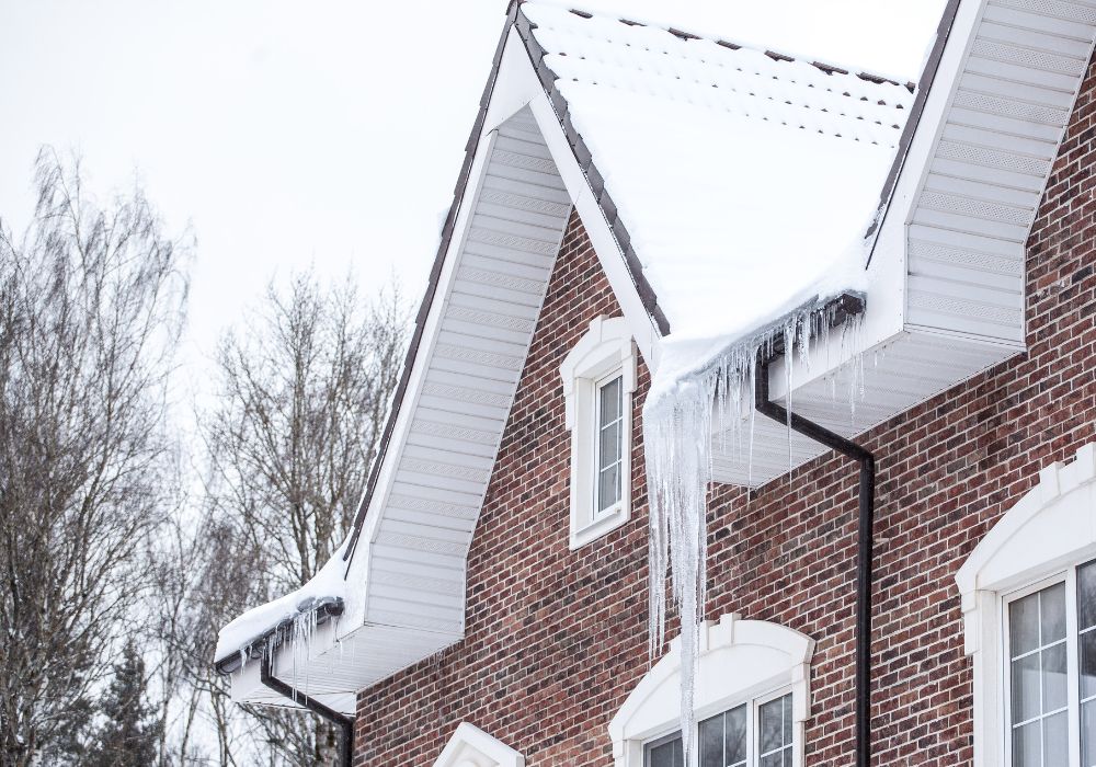 Blocked rain gutters that cause an ice dam and frozen icicles