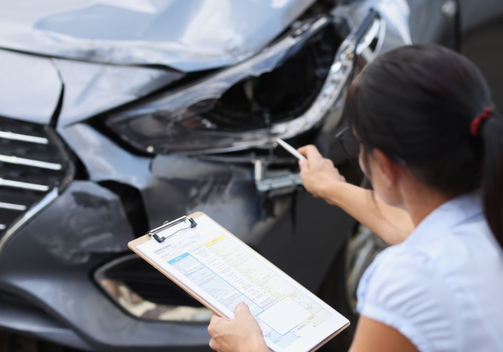 Insurance adjuster assesses vehicle after vehicle accident
