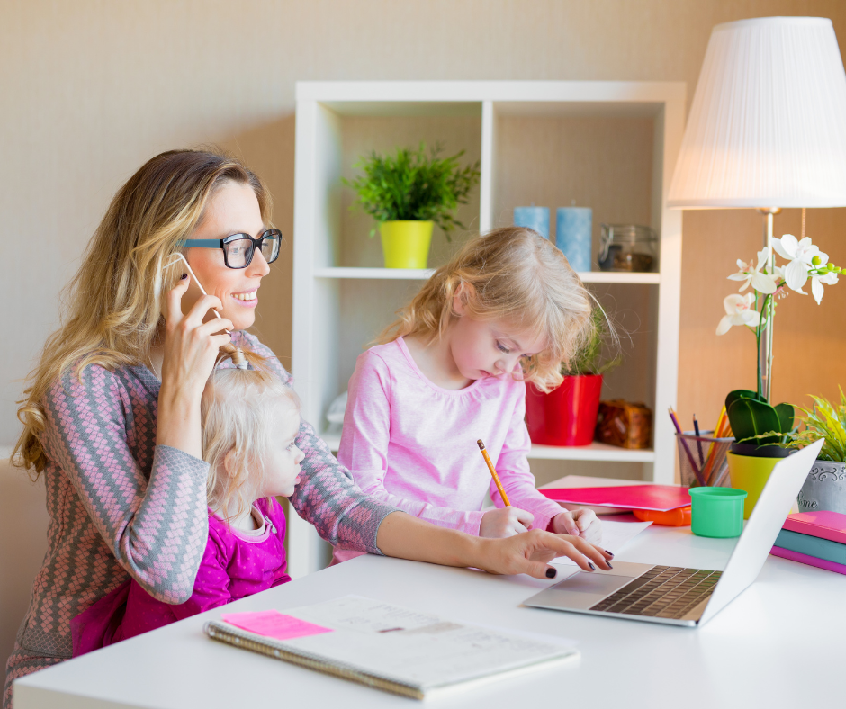 Mother working on a laptop alongside her two daughters, a home side business milestone needing a Spokane insurance review.